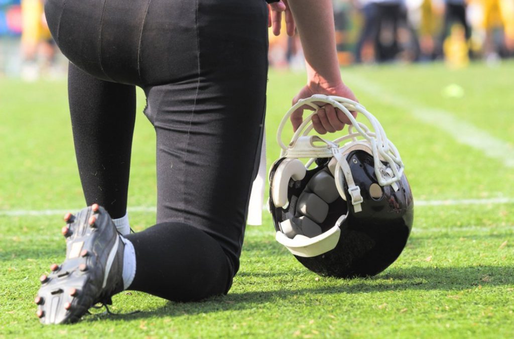 American football player kneeling before game starts